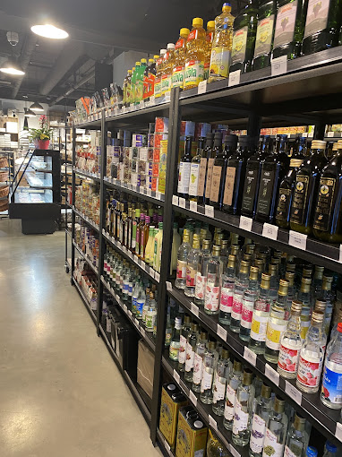 A variety of premium oils, syrups, and condiments displayed on shelves